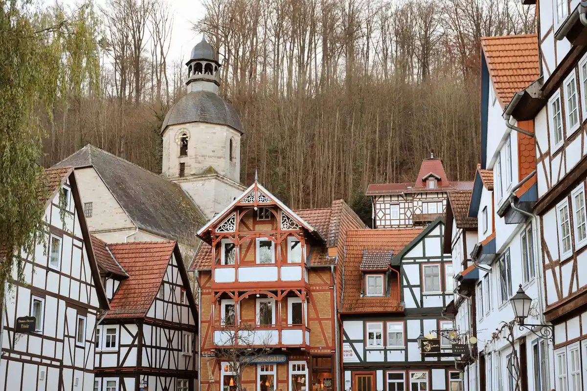 Fachwerkhäuser liegen an einer bewaldeten Anhöhe